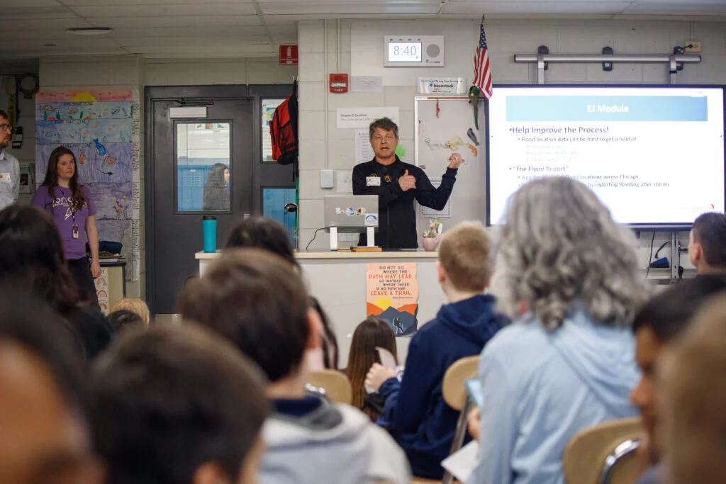 Matthew Shapiro, professor of political science at the Illinois Institute of Technology, presents before sixth graders at London about a water sample project the students were about to undertake.