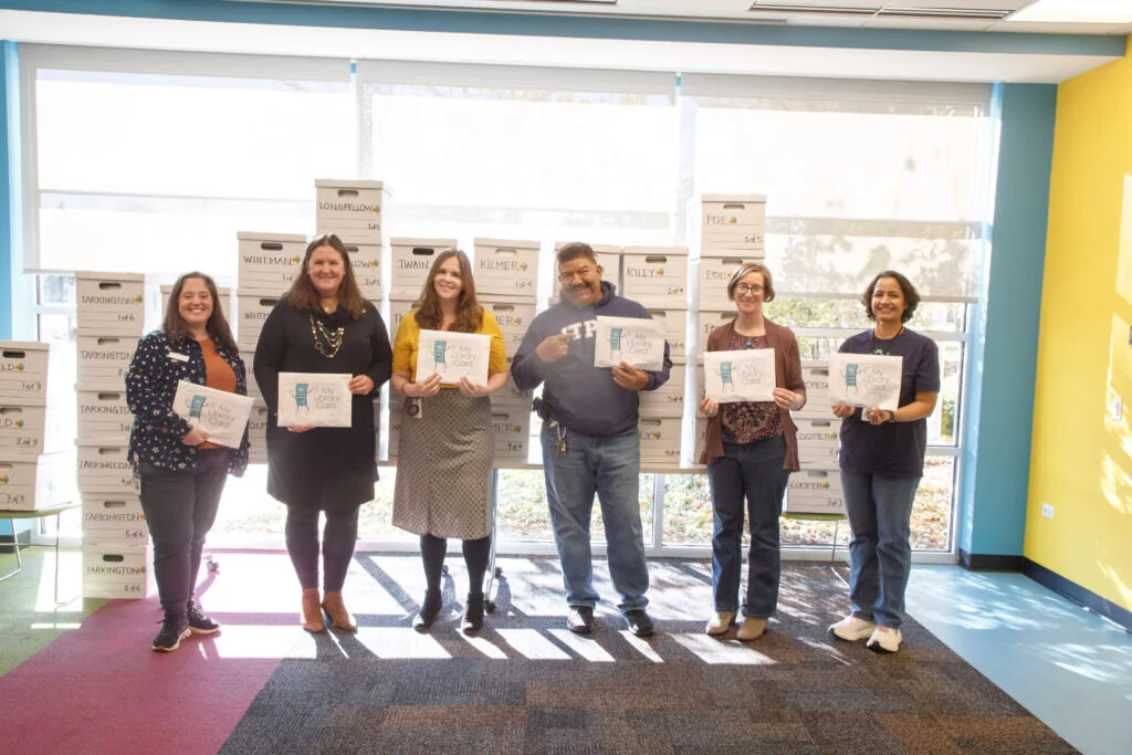 The staff at Indian Trails Public Library, standing in front of the more than 1,100 library cards and applications distributed to students across District 21.