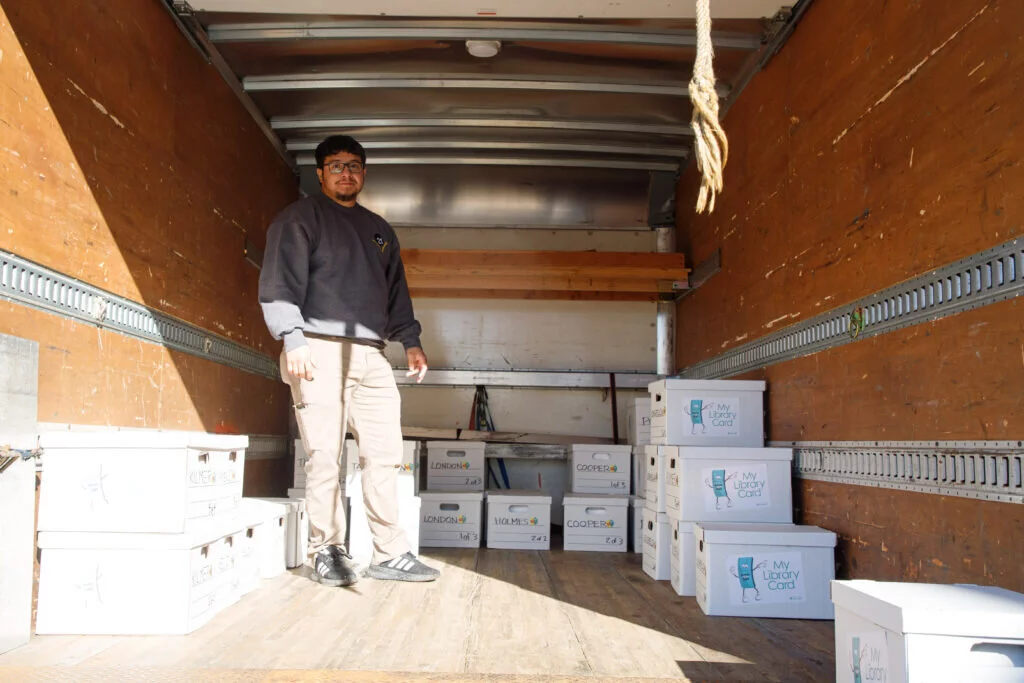 Efren Alvarado, receiving clerk for the District 21 warehouse, helps load the boxes onto the truck for delivery.