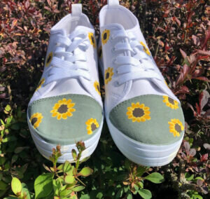 White shoes with sunflowers painted on them.