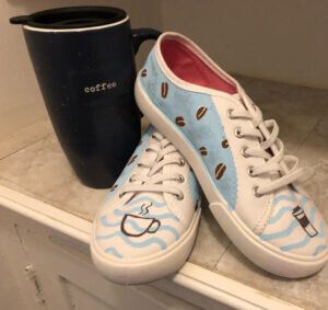 White shoes with a coffee-themed design painted on them.