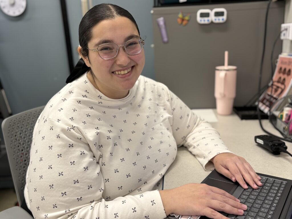 A photo of Rachel Schless sitting at her computer.