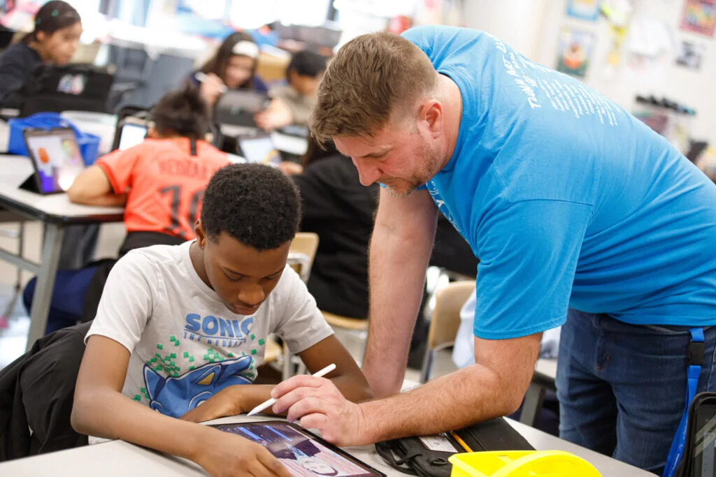 Christopher Fischer, art teacher at Twain, helps a student with his digital art assignment.